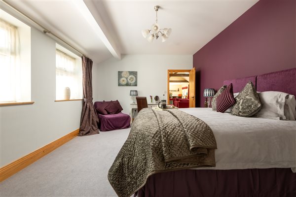 bedroom with larger superking bed, chair and dressing table